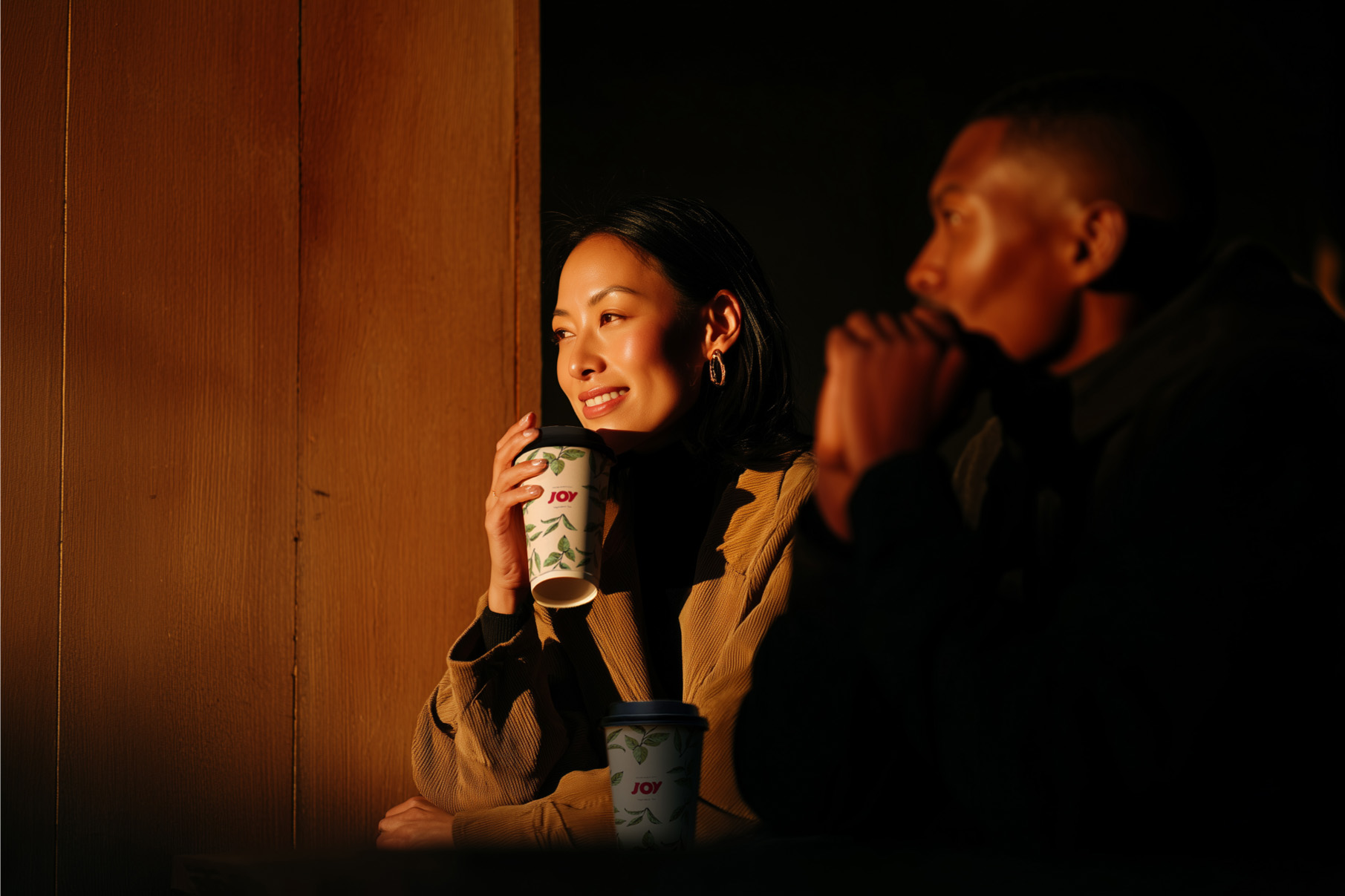 A woman smiling with a cup of Joy Tea