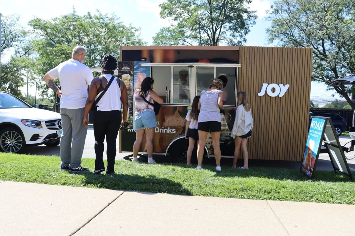 Customers lining up at the Joy Tea trailer on a summer day